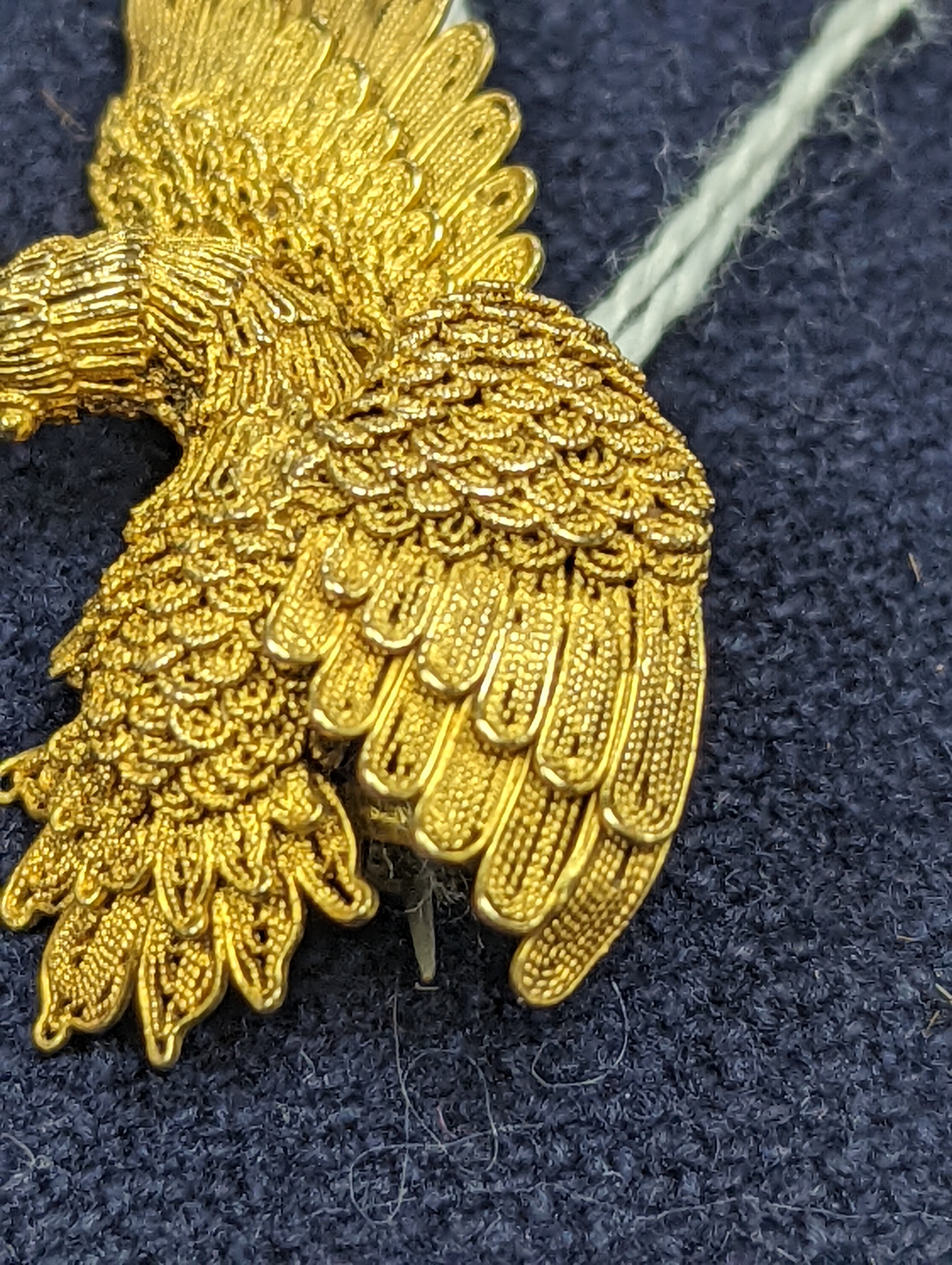 A Chinese filigree yellow metal eagle brooch, stamped 'WS 20 (with character marks)', 36mm, gross 6.5 grams.